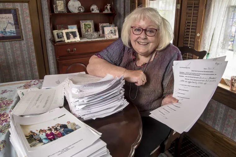 Retired English professor Cheryl Copeland with a stack of her general knowledge test.