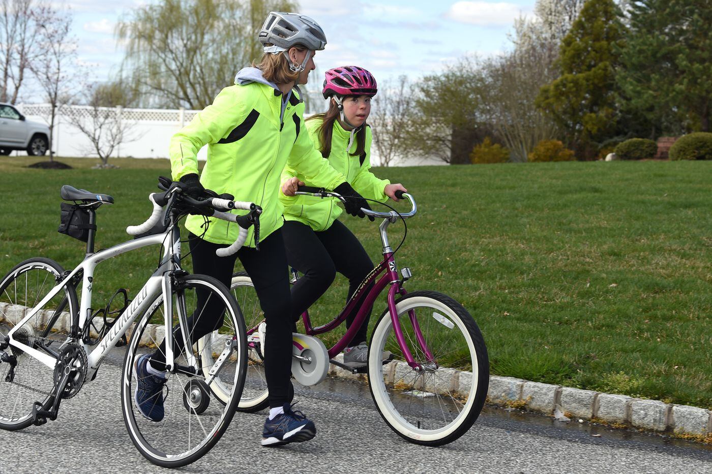 Lori Wells (left) helps her daughter Claire, 18, ride bikes in their Mullica Hill neighborhood. Claire has Down Syndrome, and because of her history of pneumonia, the family is taking particular care with social distancing during the coronavirus pandemic.
