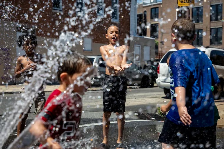 Emmanual Alvarez, 9, center, is playing in the water from a fire hydrant at Jasper and Monmouth Streets on a hot summer day in 2019.