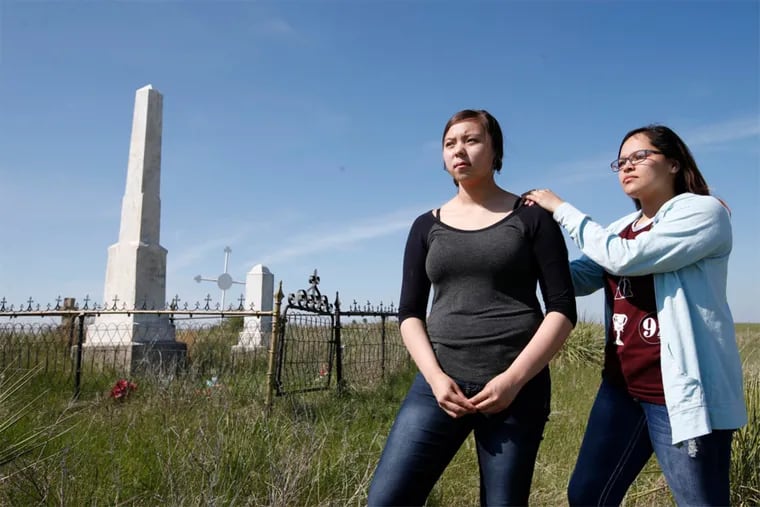 Asia Gilbertson Black Bull, left, and Shylee Brave of the Sicangu Youth Council, stand by the the grave of Chief Spotted Tail on May 12, 2016.  Spotted Tail was among the first chiefs to agree to send children to Carlisle.