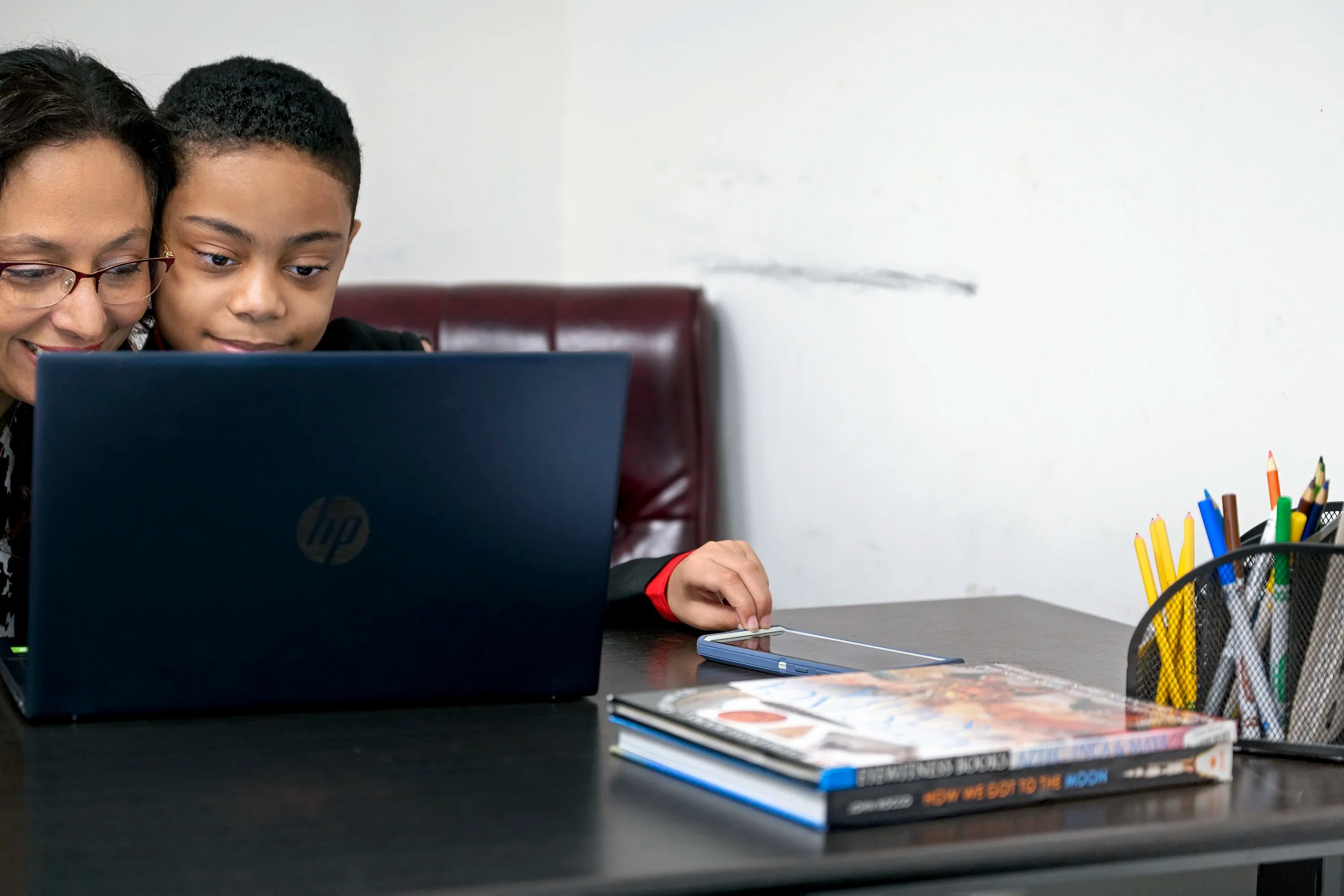Ronya Balogun looks at a computer with her 9-year-old son David, who just graduated from high school. 