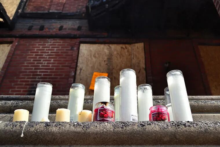 A candle memorial has been set up on the front steps of the home that claimed the lives of four children in Saturday's house fire.  Tuesday, July 8, 2014.  C.F. Sanchez / Staff Photographer