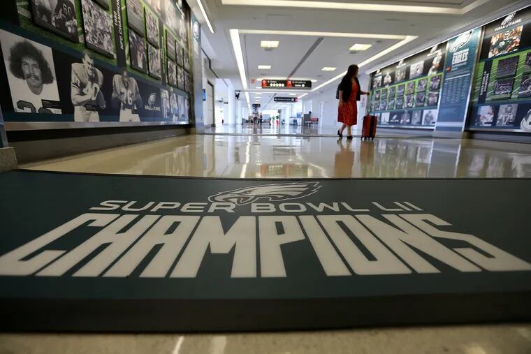 A passenger looks at the new exhibit celebrating the Eagles' championship season at Philadelphia International Airport on June 25, 2018. The exhibit is located in the A East terminal and will be on display for a year.