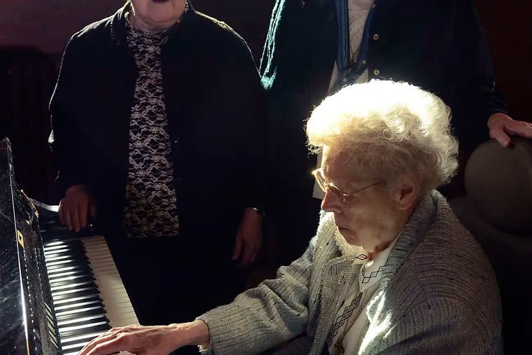 Sister Ruth Sattler plays the piano as Sister Fran (left) and Sister Donna Marie Beck sing to commemorate the 100th anniversary of the writing of "In a Manger Lowly,"