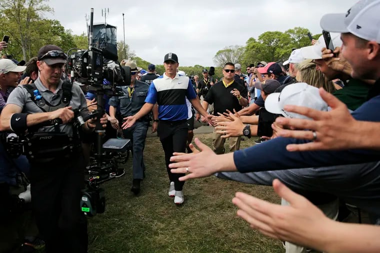 Brooks Koepka is greeted by fans as he walks up the 10th green on Sunday.