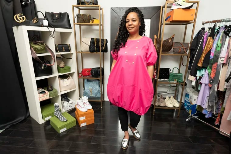 Chanel Young, left, tries on a pink bubble dress with Shani Newton, right, the owner of Dolly’s Boutique, at the Boutique, in Mt. Airy, Friday, March 24, 2023.