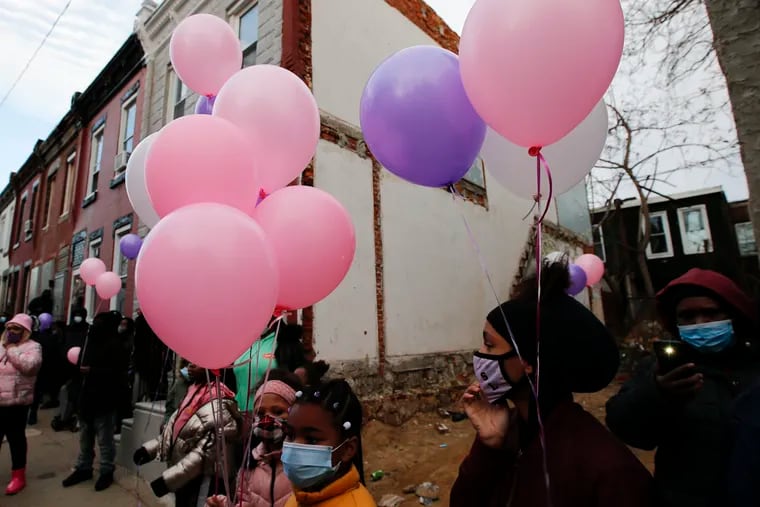 Children hold balloons in memory of Nyssa Davis, 9, who was shot in the head in her home on the 2300 block of North Bouvier Street in North Philadelphia.