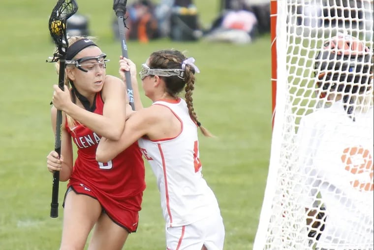 Lenape’s Lauren Figura (left) gets checked by Cherokee’s Olivia Singer near the Chiefs net during the first half of a girls’ lacrosse game on April 29 at Cherokee. Lenape went on to win, 18-8.