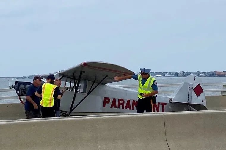 Police examine a banner plane that made an emergency landing on the bridge between Somers Point and Ocean City on Monday, July 19, 2021.