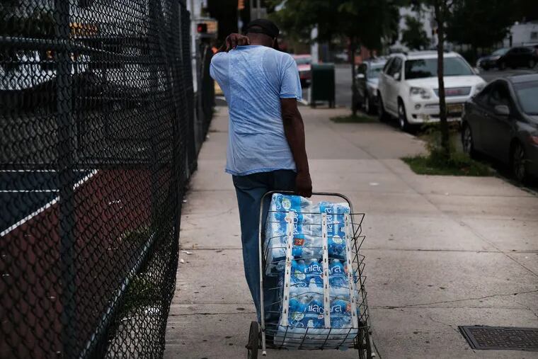 People wait in line for bottled water at a recreation center on August 13, 2019 in Newark, New Jersey.