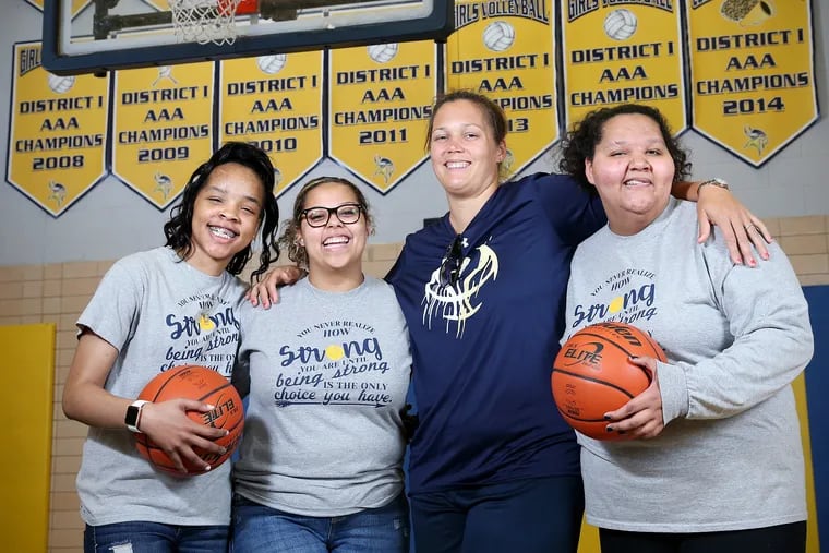 Sophomores Ty'meriah Stanton (left); Hannah Foster (second from left); and her twin sister, Jenna (right), with girls' basketball coach Leah Shumoski at Upper Merion Area High School. The three girls were injured in a crash last summer.