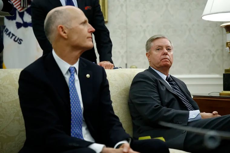 Sen. Rick Scott (left, R-Fla.) and Sen. Lindsey Graham (R-S.C.) listen as President Donald Trump and Turkish President Recep Tayyip Erdogan meet in the Oval Office with Republican senators at the White House on Wednesday.