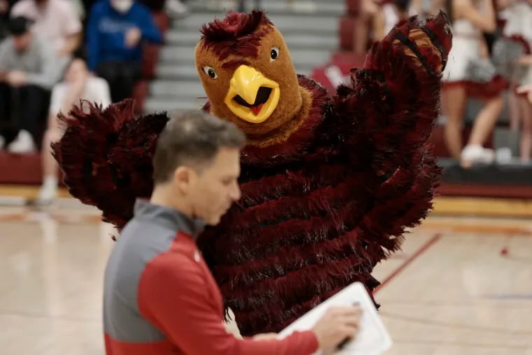 The St. Joe’s hawk runs around as Joe’s head coach Billy Lange takes a time out in the second half of the George Washington at St. Joseph’s University division A-10 mens basketball game at St. Joe’s Hagan Arena in Phila., Pa. on Jan. 19, 2022.