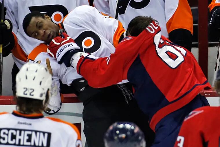Flyers right wing Wayne Simmonds (17) and Washington Capitals defenseman Steve Oleksy (61) fight in front of the Flyers bench, in the third period of an NHL hockey game, Sunday, Dec. 15, 2013, in Washington. The Capitals won 5-4 in a shootout. (Alex Brandon/AP)