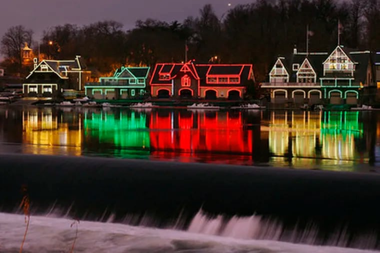 LIGHTS REFLECTED in the Schuylkill along Boathouse Row provide a festive yuletide scene. The best place to view the scene is from across the river on Martin Luther King Jr. Drive.