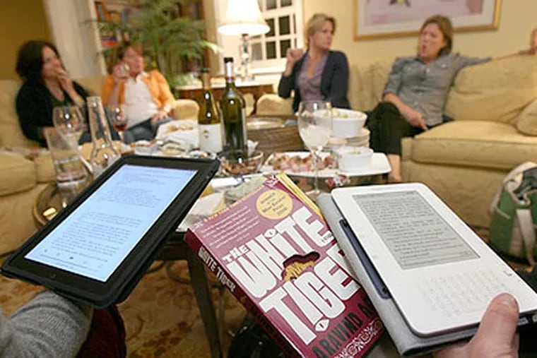 That Book Club members in Villanova discuss Aravind Adiga’s “The White Tiger,” using (from left) an iPad, a book, and a Kindle.  (Charles Fox / Staff Photographer)