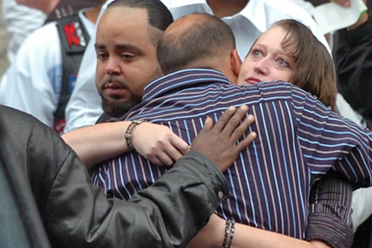 Luis Rosario, father of Gina Marie Rosario, 7, is comforted by loved ones after his daughter’s Funeral Mass at St. Peter’s Church at Fifth Street and Girard Avenue. Gina was one of three children killed when a driver fleeing police crashed into them. (Sarah J. Glover / Staff Photographer)