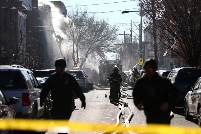 Firefighters battle a fire after an apparent explosion in the 1400 block of South 8th St. in Philadelphia on Thursday, Dec. 19, 2019.