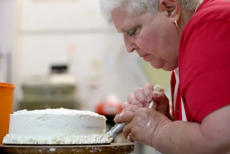 Roz Bratt finishing up a carrot cake at her shop, Homemade Goodies by Roz, on Fifth Street near Lombard.