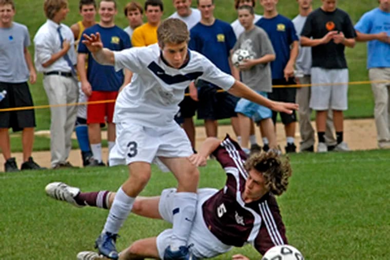 St. Joseph&#0039;s Prep&#0039;s Mike DiMarco goes down as he duels with La Salle&#0039;s Pat Sinnott for possession of the ball in the first half.