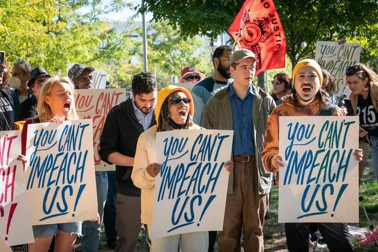 Protesters rally against an effort by state legislators to impeach District Attorney Larry Krasner during hearings at the Navy Yard last month.