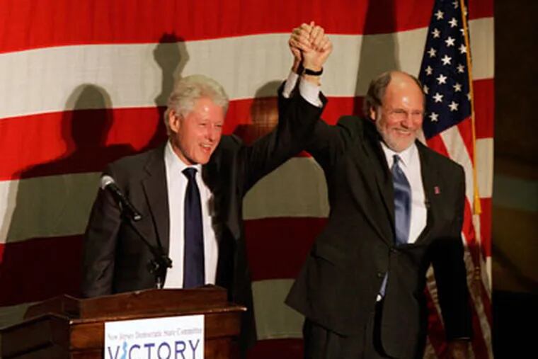New Jersey Gov. Jon S. Corzine, right, and former President Bill Clinton hold arms up during a campaign stop for Corzine today in Collingswood, N.J. (AP Photo/Mel Evans)
