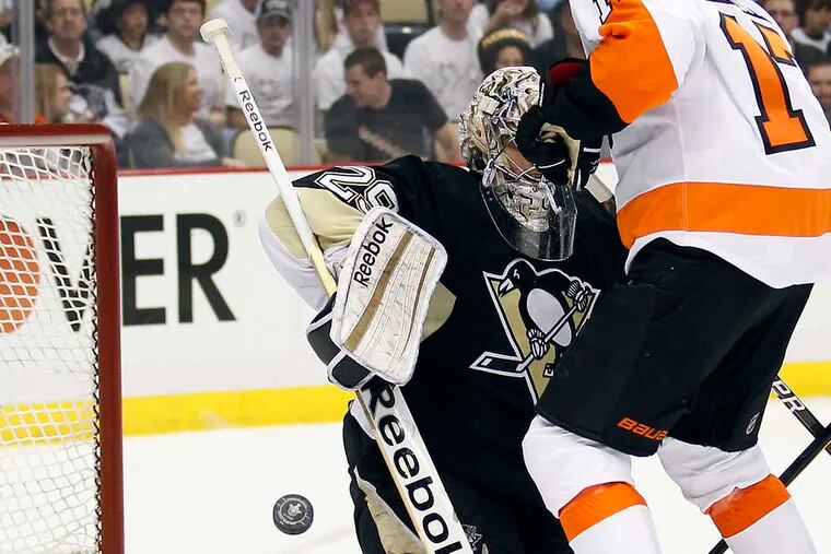 The Flyers' Wayne Simmonds goes for the puck in front of the Penguins' Marc-Andre Fleury.