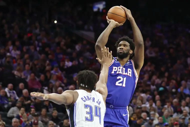 76ers center Joel Embiid shoots over the Orlando Magic's Wendell Carter Jr. on Wednesday.