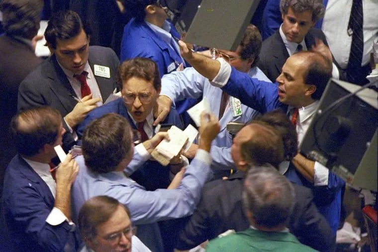 In this Oct. 19, 1987 photo, traders work on the floor of the New York Stock Exchange.
