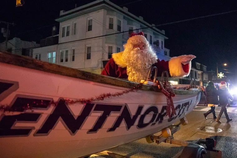 John W. Brenner III of Northfield, N.J., a retired Atlantic City fire captain, waves at kids and families as he rides in a Ventnor lifeguard boat dressed as Santa Claus for the Ventnor Twilight Holiday Parade on Saturday.