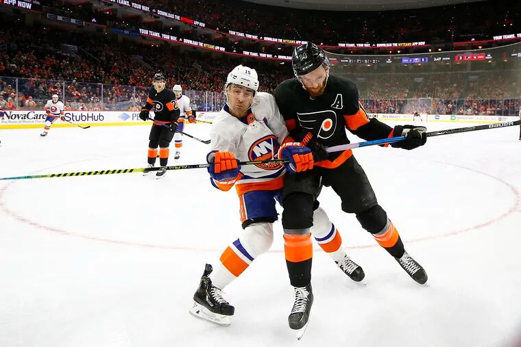 Flyers center Sean Couturier checks New York Islanders right wing Cal Clutterbuck during the second-period on Saturday, November 16, 2019 in Philadelphia.