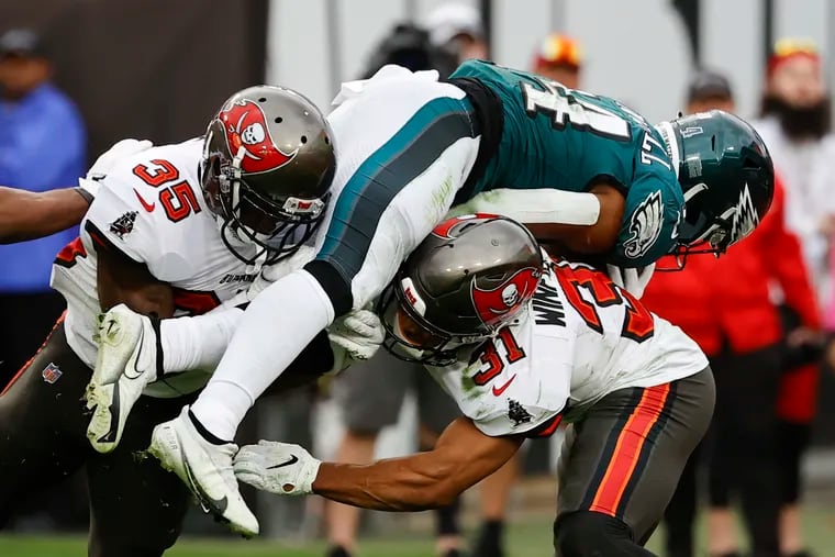 Eagles running back Kenneth Gainwell scores a fourth-quarter touchdown against Tampa Bay Buccaneers cornerback Jamel Dean (left) and Buccaneers safety Antoine Winfield Jr., in the NFC Wildcard playoff game in Tampa Bay.
