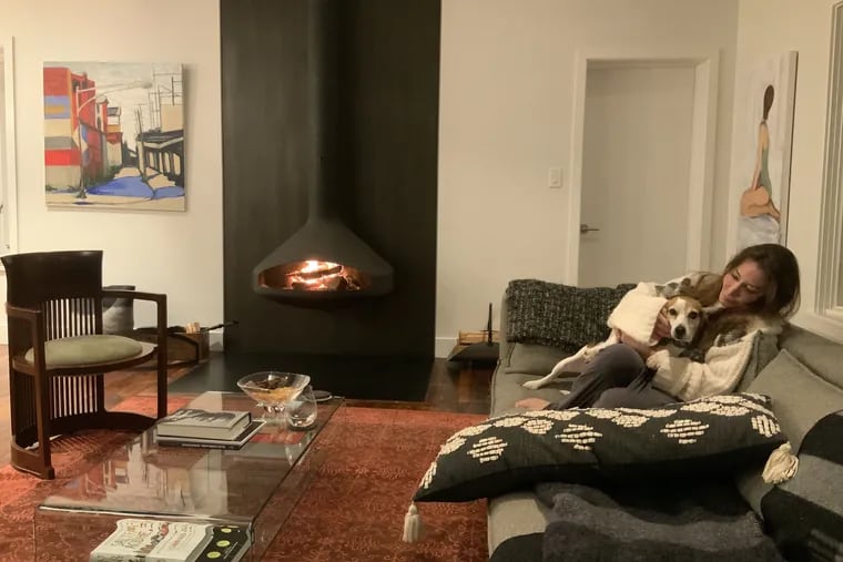 Laura Berland and rescue Beagle, Cammie, cuddle in front of their wood-burning fireplace, which efficiently heats their entire living room and kitchen.