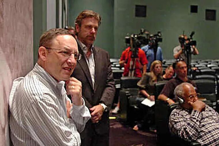 Eagles president Joe Banner (left) listens as Donovan McNabb talks about his new deal.