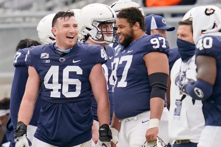 Penn State defensive end Nick Tarburton laughs with defensive tackle PJ Mustipher during spring practice in April.