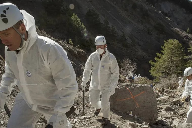 In this photo provided Friday, April 3, 2015 by the French Interior Ministry, French emergency rescue services work among debris of the Germanwings passenger jet at the crash site near Seyne-les-Alpes, France. The co-pilot of the doomed Germanwings flight repeatedly sped up the plane as he used the automatic pilot to descend the A320 into the Alps, the French air accident investigation agency said Friday. (AP Photo/Yves Malenfer, Ministere de l'Interieur)
