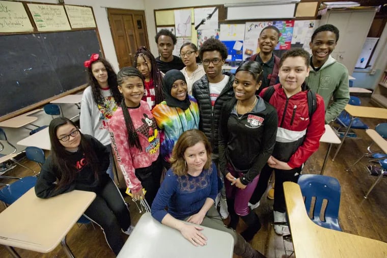 Ninth-grade English teacher Maureen Boland of Parkway Center City Middle College in Philadelphia is surrounded by students who participated in the March 14 walkout against gun violence in schools.