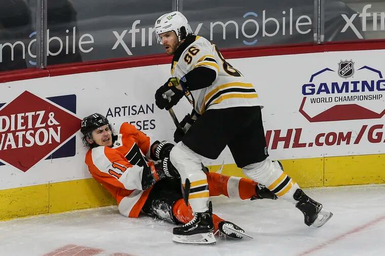 Flyers forward Travis Konecny slashes the Bruins' Kevan Miller. Both players received minor penalties.