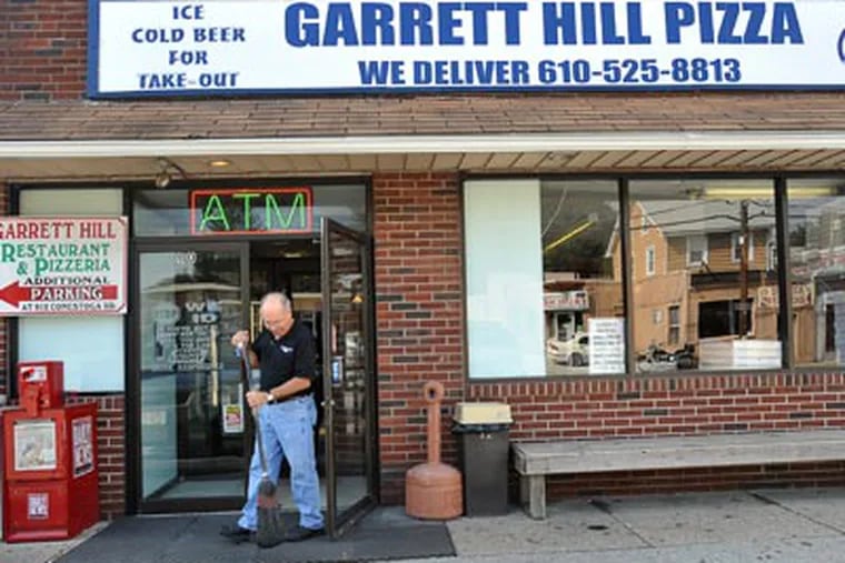 Joe Marchesani, owner of Garrett Hill pizza, sweeps clean the entrance to his restaurant before opening. ( Sharon Gekoski-Kimmel / StaffPhotographer )