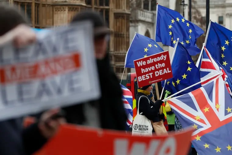 Pro and anti Brexit demonstrators wave their placards and flags outside the Houses of Parliament in London, Tuesday Dec. 18, 2018. The British Cabinet was meeting Tuesday to discuss ramping up preparations for Britain's departure from the European Union without a deal, after Prime Minister Theresa May postponed Parliament's vote on her divorce agreement until mid-January. (AP Photo/Alastair Grant)