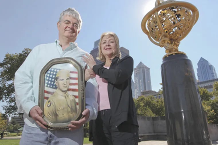 Paul Karosas and Monica Cullen hold a portrait of their uncle Joseph Karaso near the Franklin Institute. (Michael Bryant / Staff Photographer)