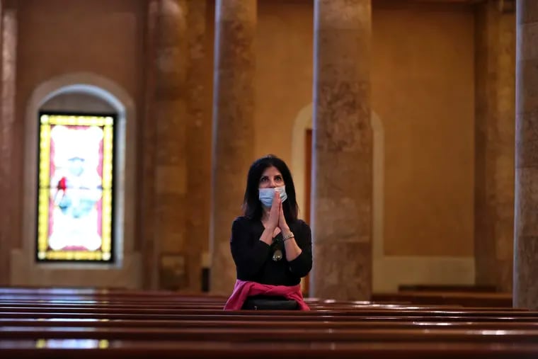 A Christian worshipper prays in Lebanon, the latest country to reimpose restrictions after experiencing a surge of coronavirus infections.