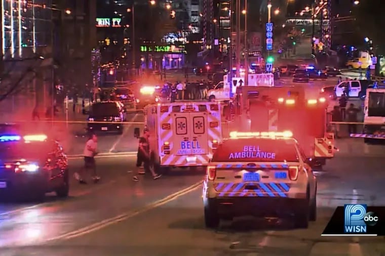 This photo taken from video provided by WISN 12 News shows police responding to the scene of a shooting at Water Street and Juneau Avenue in Milwaukee, Friday, May 13, 2022.  Twenty people were injured in two shootings in downtown Milwaukee near an entertainment district where thousands of people were watching the Bucks play the Celtics in the NBA's Eastern Conference semifinals, authorities said. There was no immediate indication whether the two shootings were related or involved fans who were watching the game.