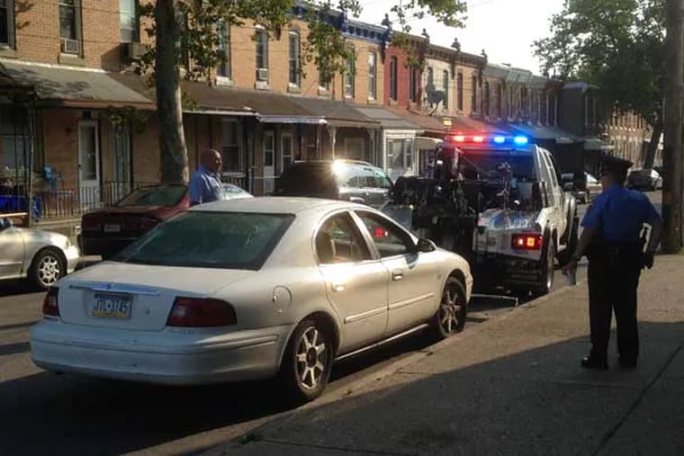Police tow a car from the scene of a quadruple shooting in Nicetown that left two men dead. (Emily Babay/staff)