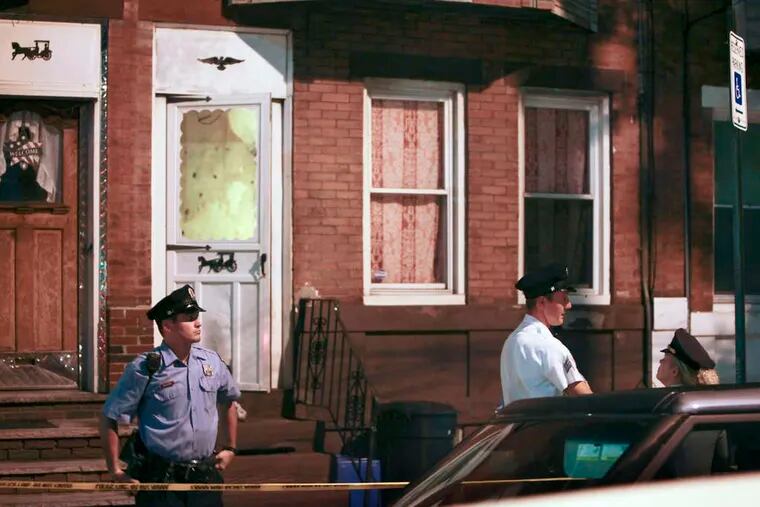 Investigators outside a Port Richmond home after a woman who lived there was found dead from a gunshot wound to the head late Thursday.