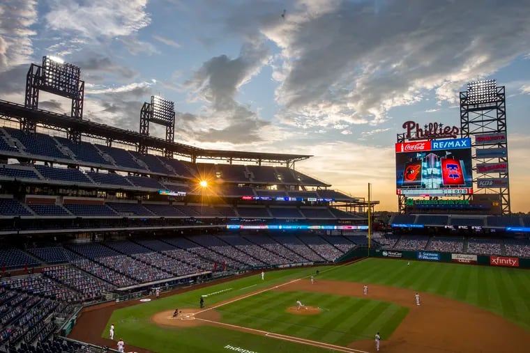 The setting sun shines through an opening as the Phillies play the Orioles on Aug. 12, 2020.