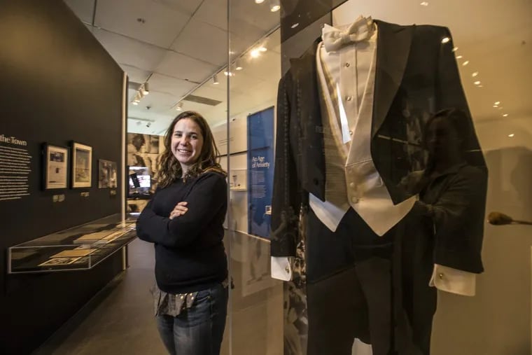 Ivy Weingram, curator of the exhibit celebrating Leonard Bernstein, stands next to Bernstein’s conductor suit made for him by Otto Perl. MICHAEL BRYANT / Staff Photographer