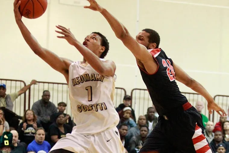 Quade Green , left, of Neumann-Goretti  up for a basket past Devin Liggeons, right of Imhotep Charter in the 4th quarter in the PIAA Class AAA semifinals at Philadelphia University, on March 17, 2015. Neumann-Goretti won 75-67. (Charles Fox/Staff Photographer)
