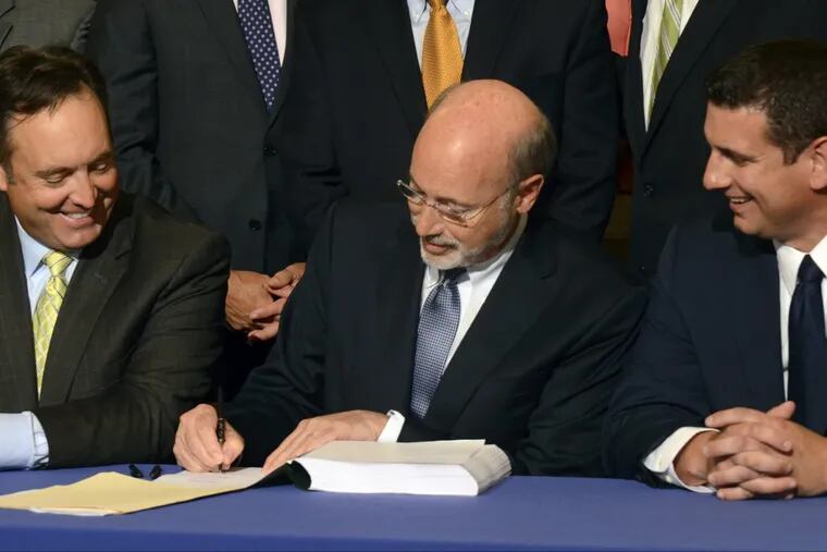 Democratic Gov. Tom Wolf signs legislation designed to reduce long-term public pension costs during a signing ceremony in the Pennsylvania Capitol on Monday, June 12, 2017 in Harrisburg, Pa. Looking on are Senate Majority Leader Jake Corman, R-Centre, right, and House Majority Leader Dave Reed, R-Indiana. (AP Photo/Marc Levy)
