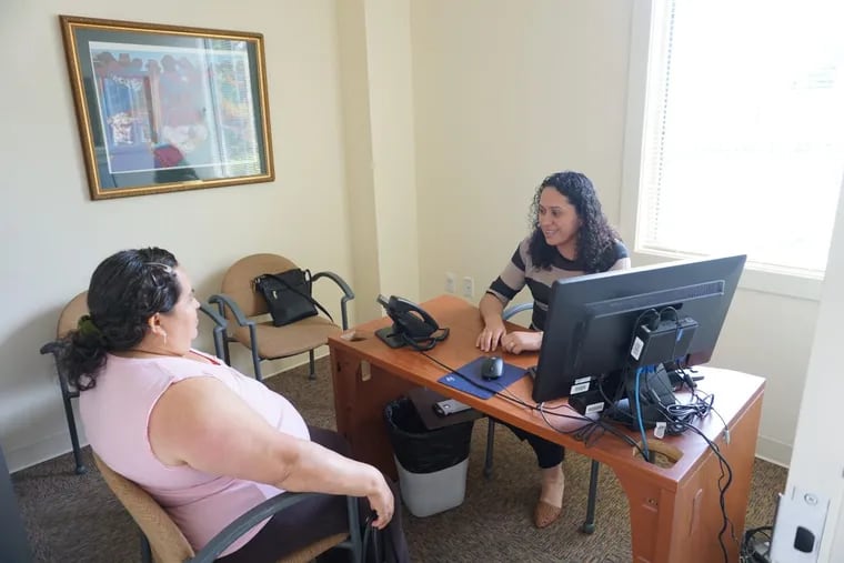 Criztina Gonzalez (right), a supervisor and certified application counselor for the Affordable Care Act healthcare marketplace, assists a client at La Comunidad Hispana in Philadelphia during a previous enrollment period.